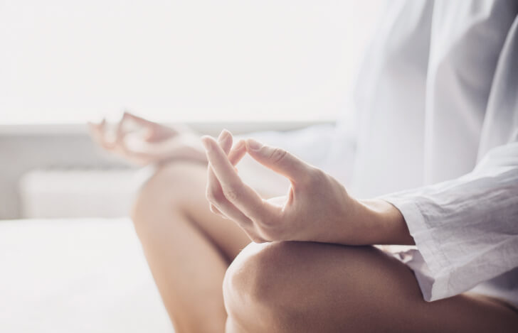 座ってチンムドラを組む人の手元