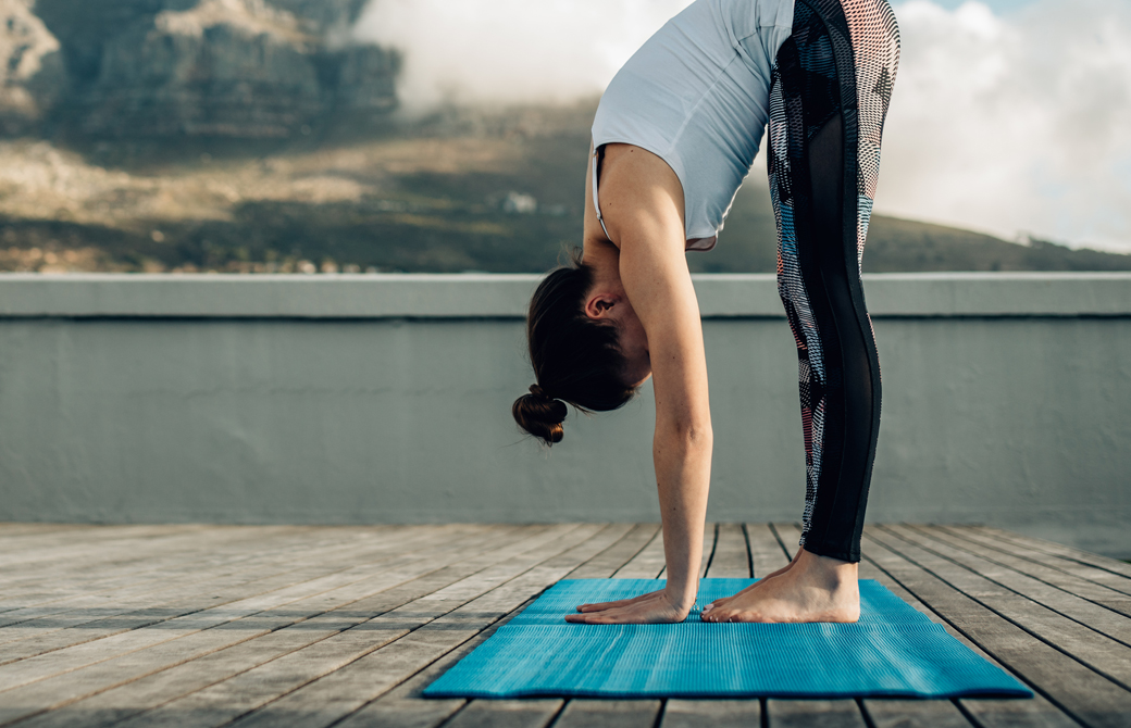 屋外でマットの上でウッターナアーサナをする女性