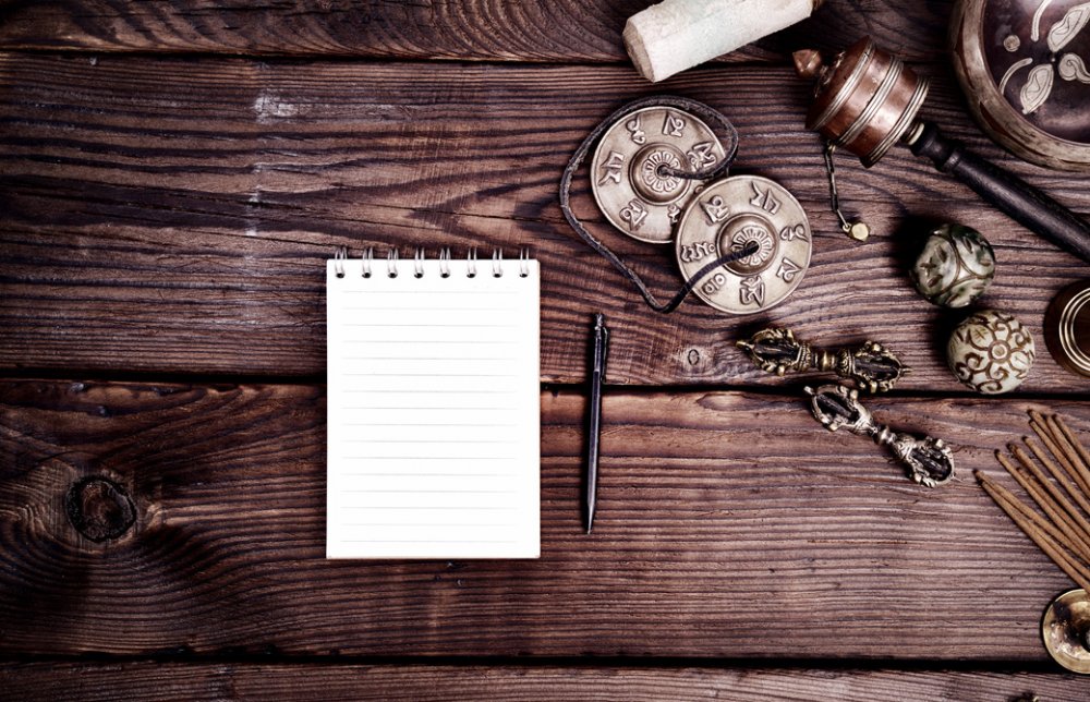 テーブルの上にティンシャなどヨガグッズが並べられノートとペンが置かれている