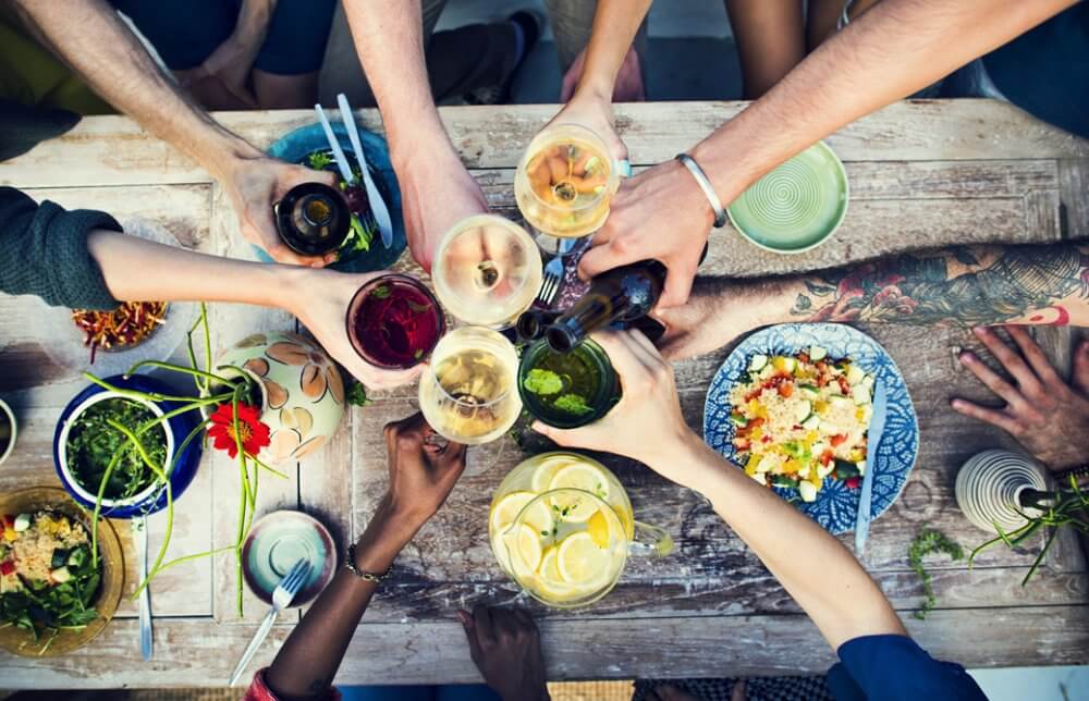 パーティーテーブルでグラスを合わせる人たち