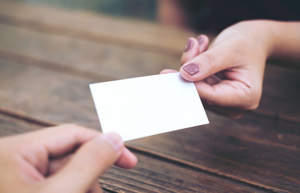 名詞を手渡ししている女性の手元