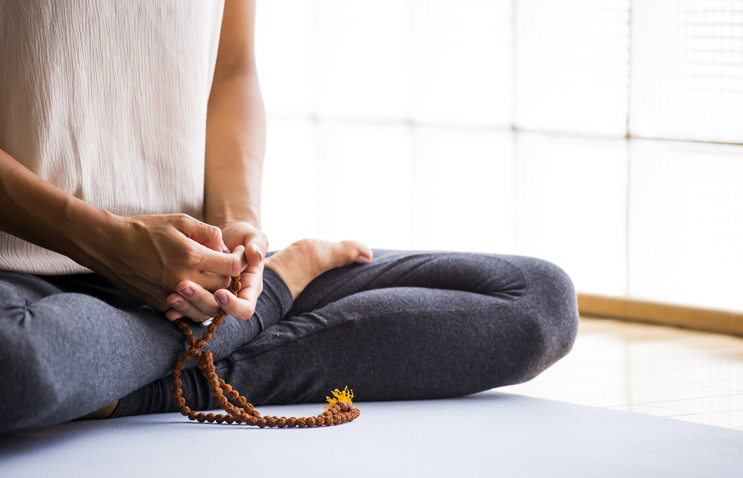 マーラービーズを数えて瞑想している女性
