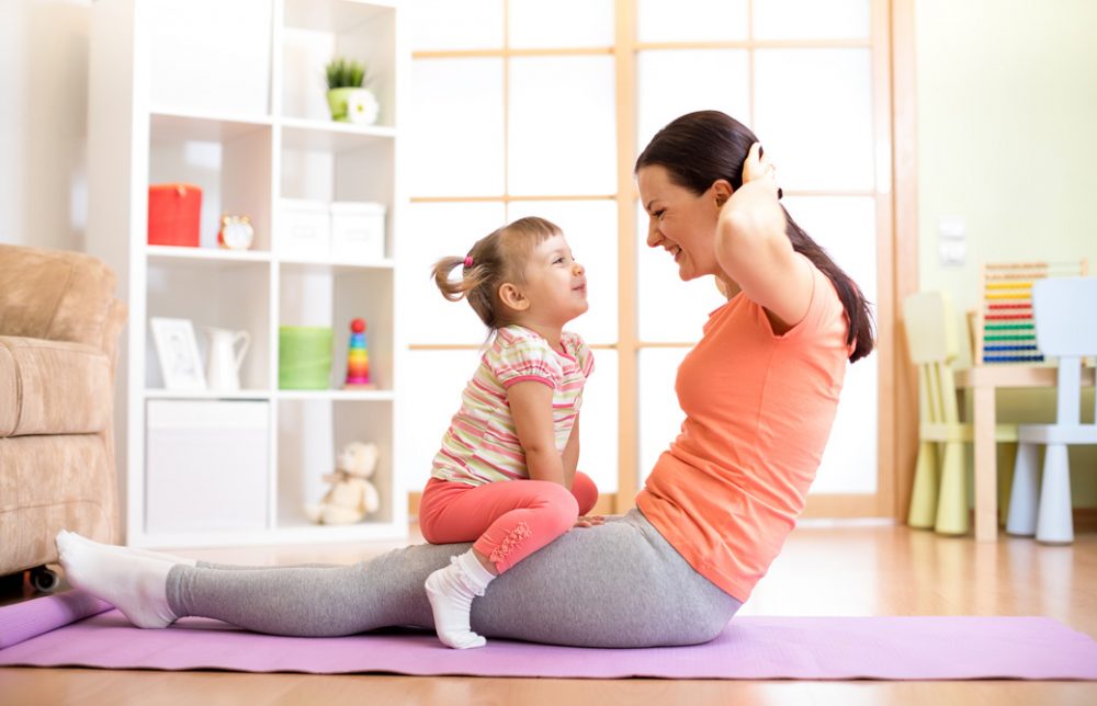 ママと少女が一緒にヨガを室内でしている
