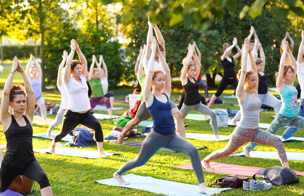 芝生の公園でヨガをしている人たち