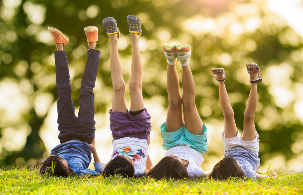 芝生の上で肩立ちのポーズをしている子どもたち