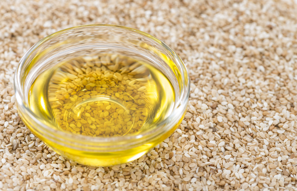 白ごまが敷き詰められた上でガラスの器に入ったごま油