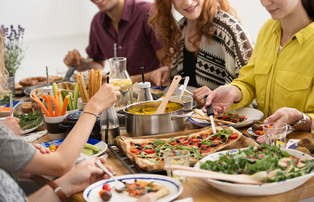 野菜に彩られた食卓を囲むひとたち