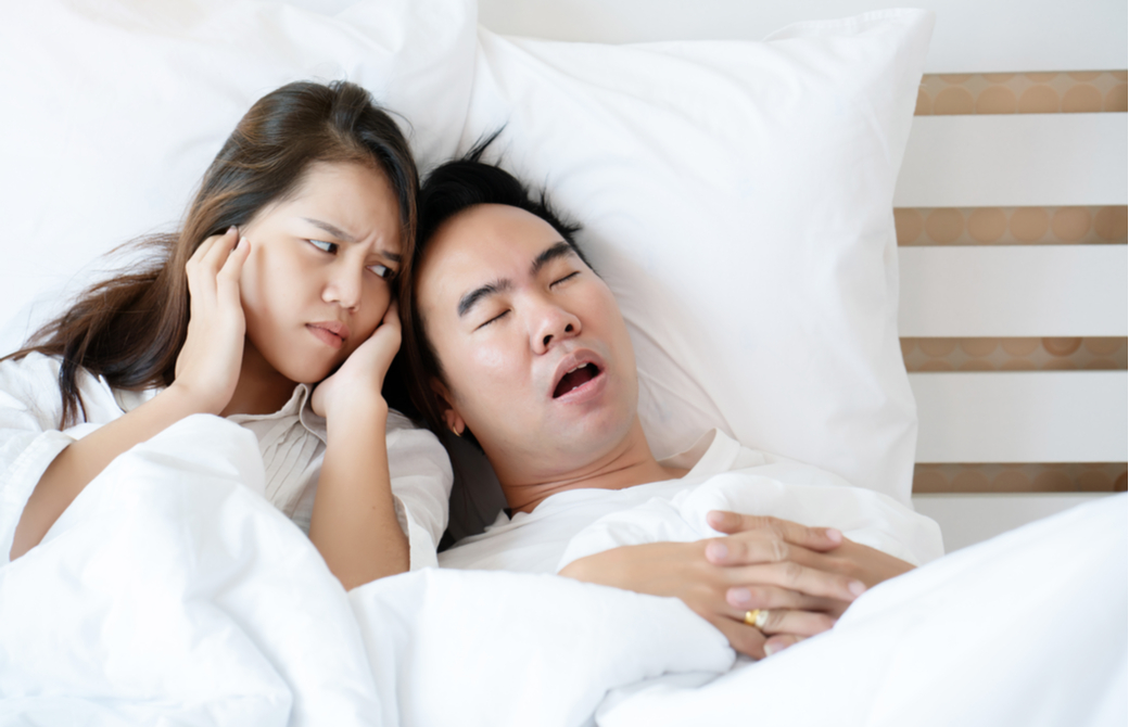 いびきをかく男性に困惑している女性