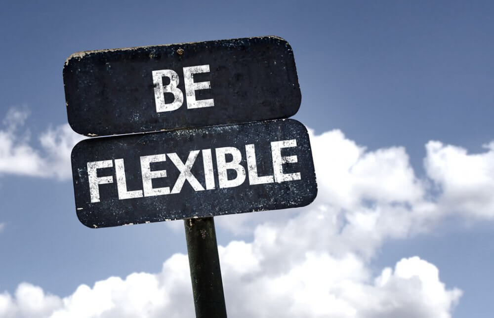 BE FLEXIBLEと書いてある看板と青空