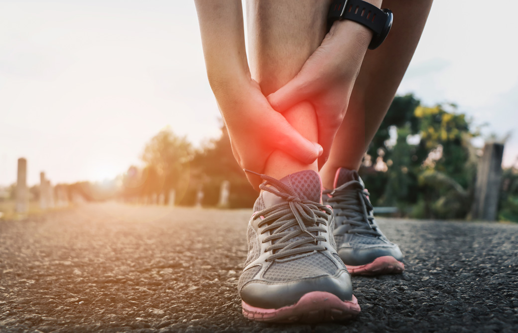 足首を怪我しておさえている人