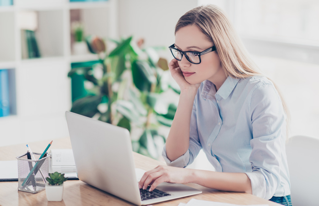 PCに向かってひじをついて作業をしている女性