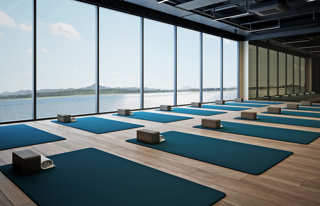 海に面した大きなガラス張りのヨガスタジオに綺麗にマットとブロックが並べられている