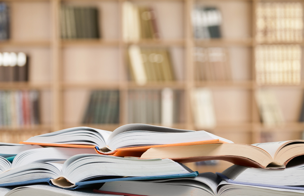 図書室で本が開かれ積まれている