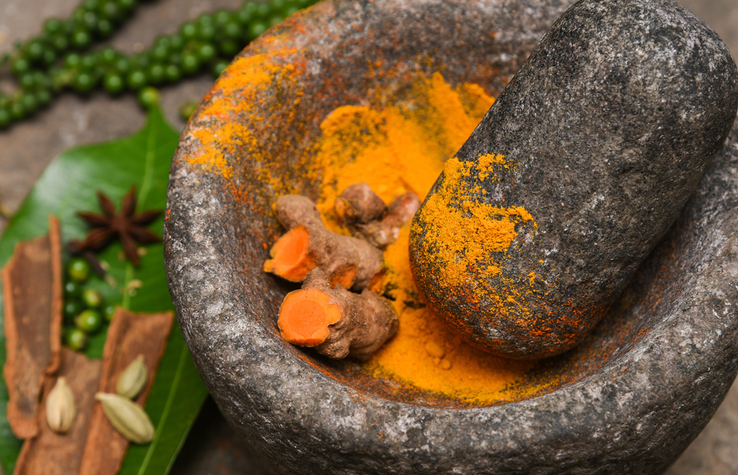 ターメリックをすりつぶして粉末を作っている