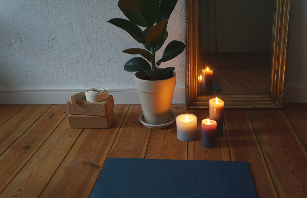 壁際のヨガプロップスとキャンドルと鏡