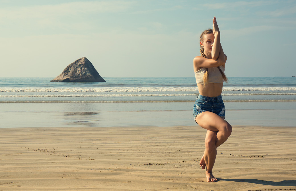 海辺でガルーダアーサナをする女性
