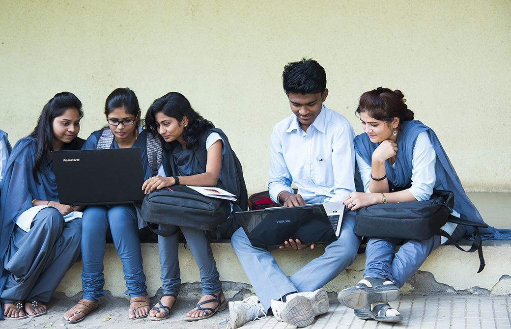 インド人の若者たちが集まって本などを一緒に見て休憩している