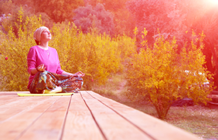 ウッドデッキに安楽座で座る女性