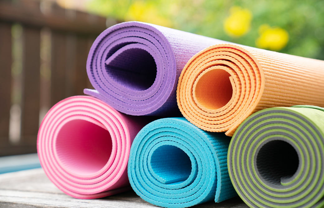 カラフルなヨガマットが積まれている