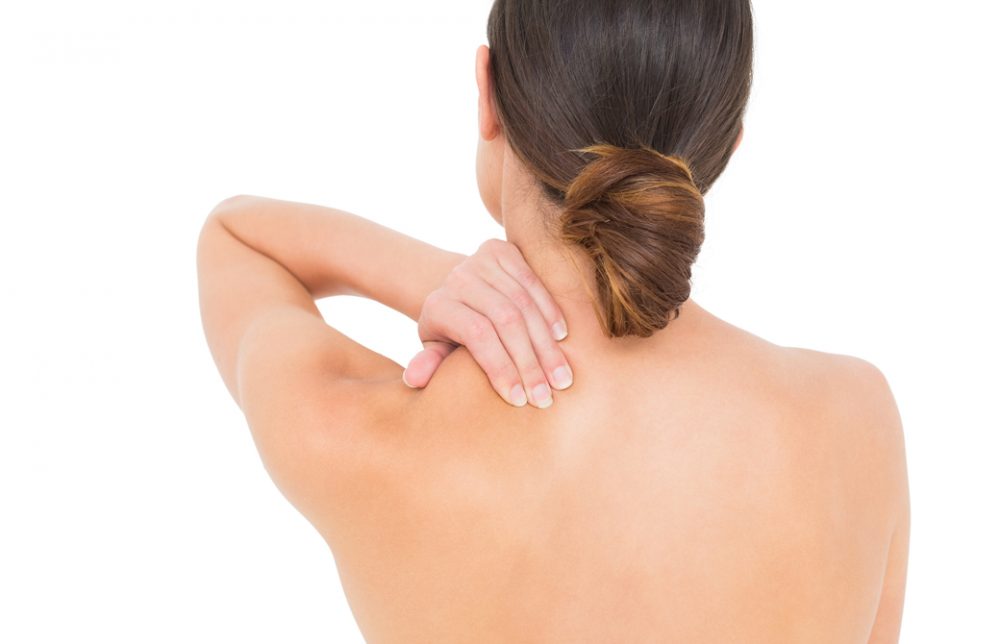 背を向けて肩をおさえている女性