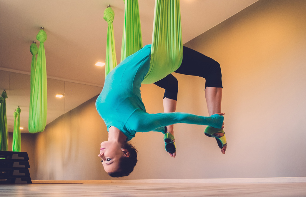 空中ヨガでウルドヴァダヌラーサナをする女性