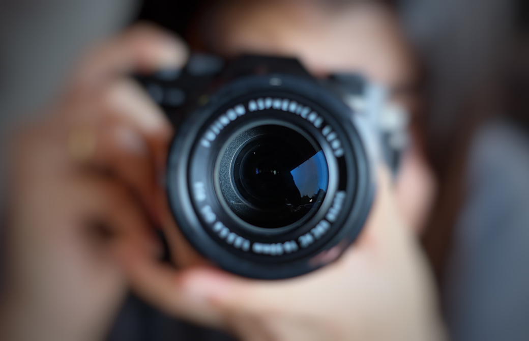 カメラを構えてファインダーをのぞいているひとの近影