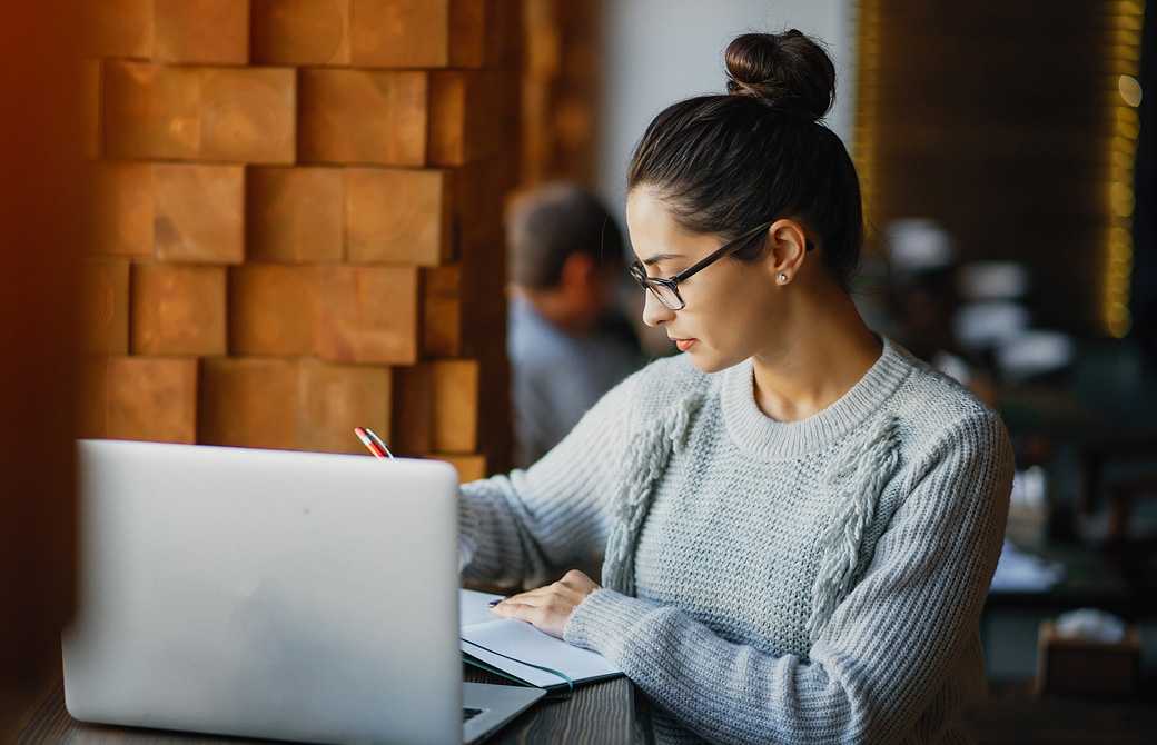 PCを開いてテキストで勉強している女性