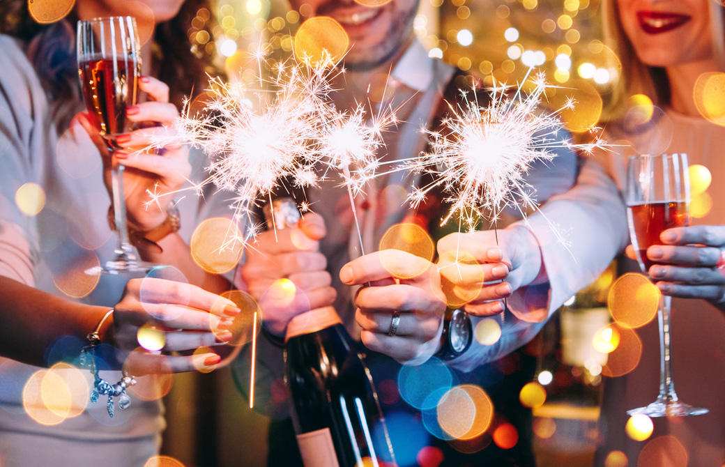 ワインボトルや手持ち花火をかざして写真を撮る人たち