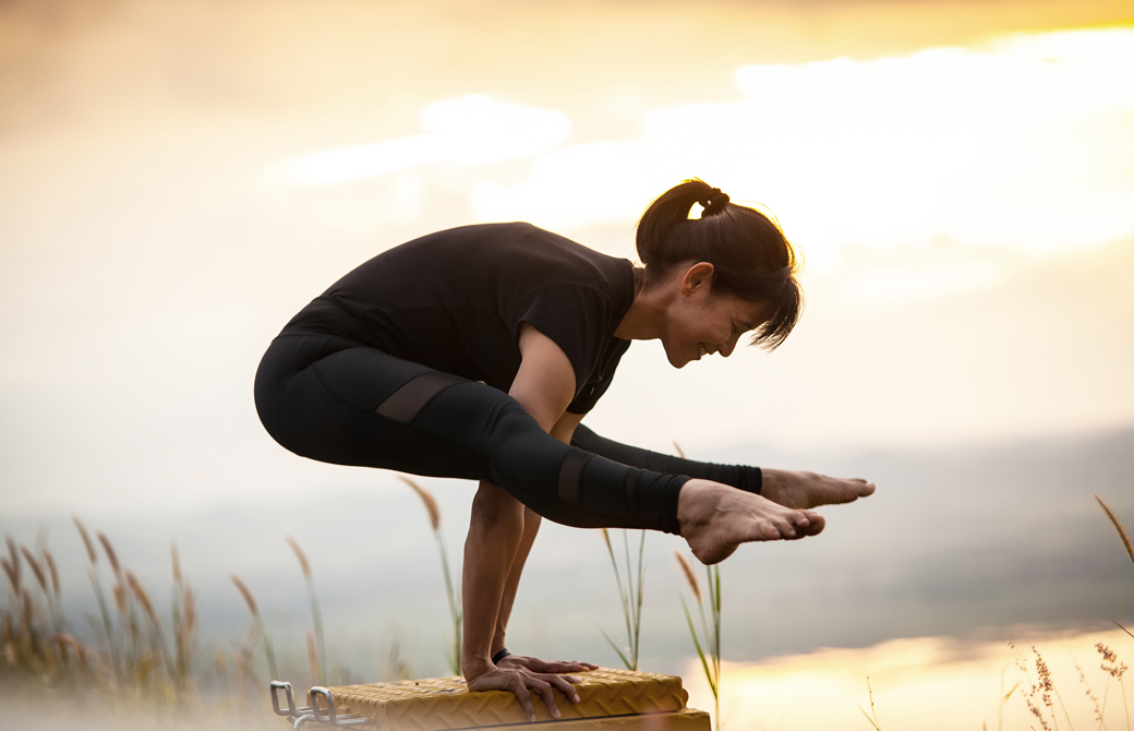 ティッティバーサナ（蛍のポーズ）をする女性