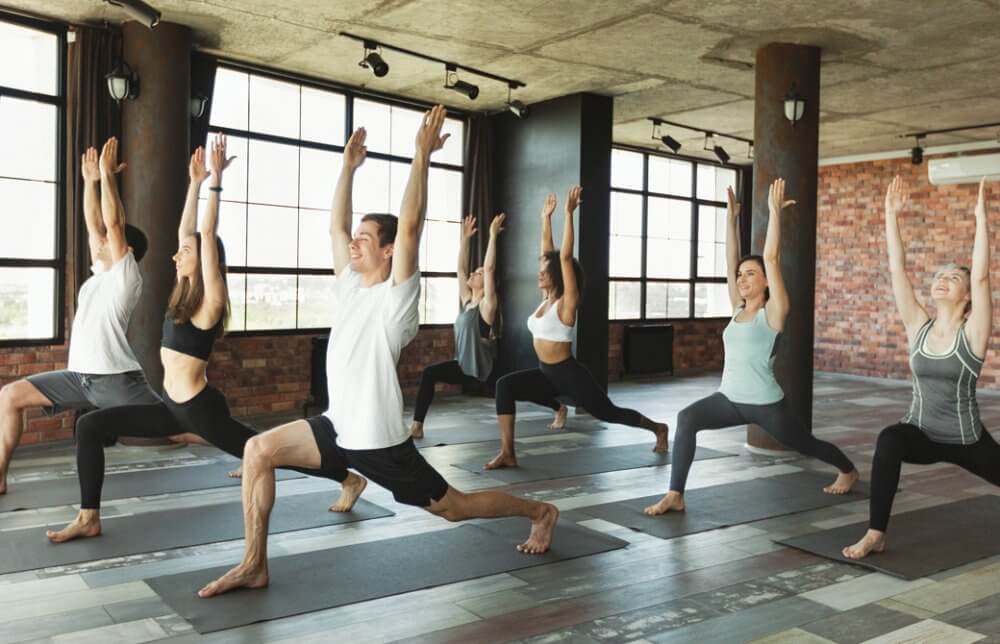 ヨガクラスでハイランジのポーズをしているひとたち