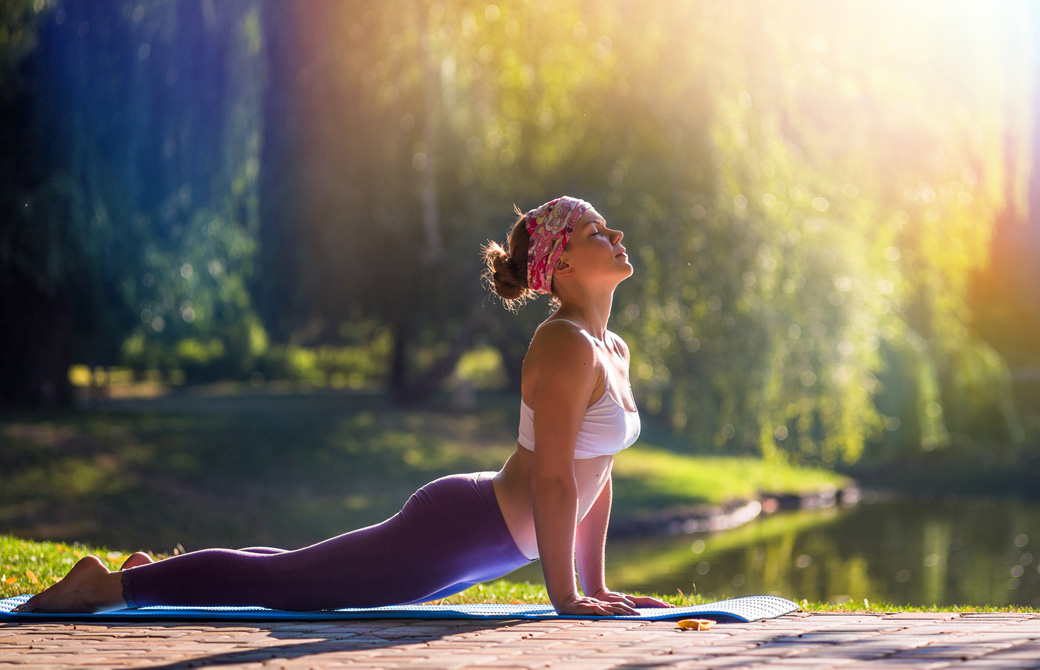 湖のほとりで気持ち良さそうにアップドッグをする女性