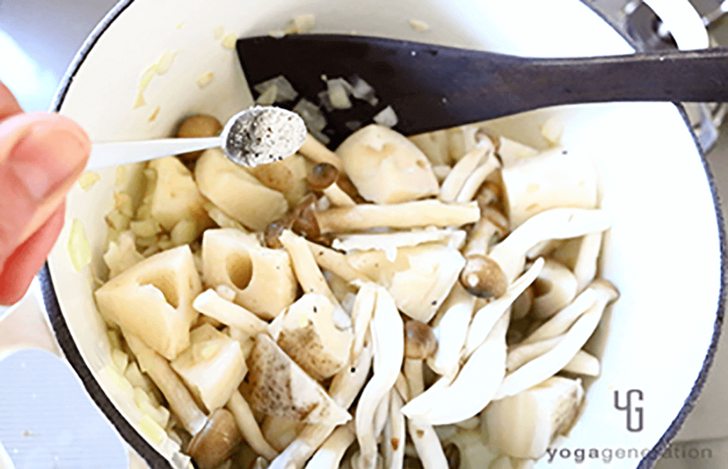 お鍋でレンコンやシメジなどの食材を炒めているところ