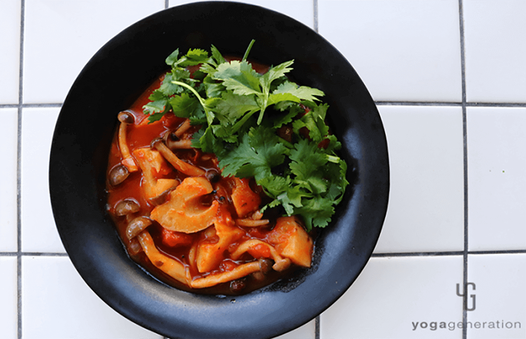 黒いお皿に盛り付けたレンコンとシメジ、お豆のメキシカン・チリ・スープ