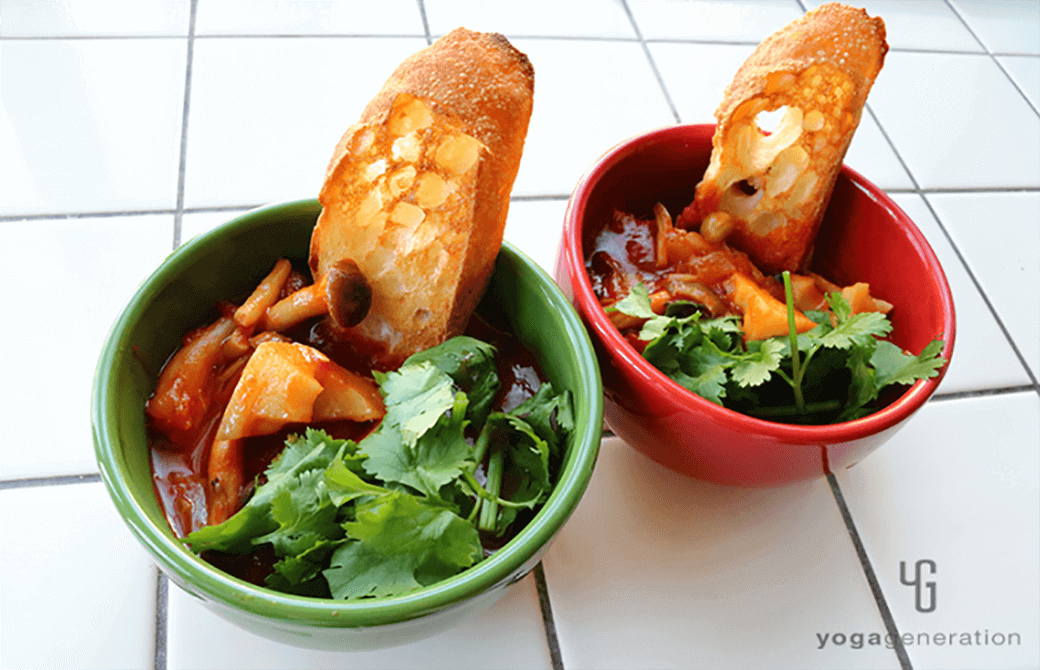 赤と緑のお皿に盛り付けたレンコンとシメジ、お豆のメキシカン・チリ・スープ