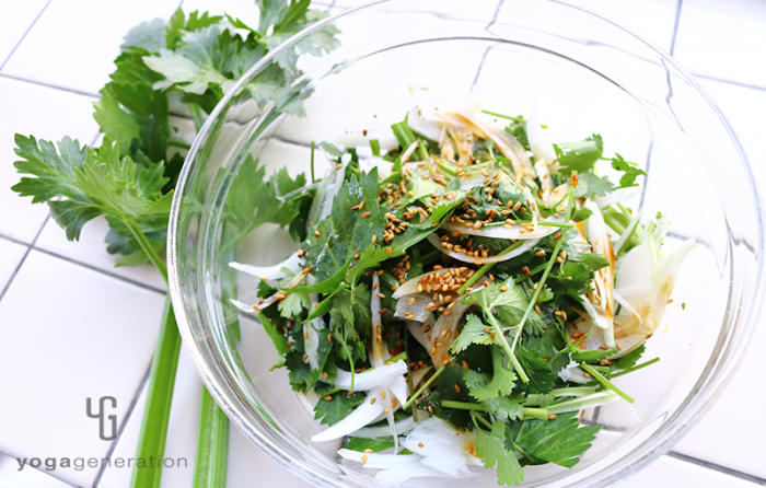 ガラスボウルに盛り付けたセロリと新玉ねぎ、パクチーのピリ辛ゴマサラダ