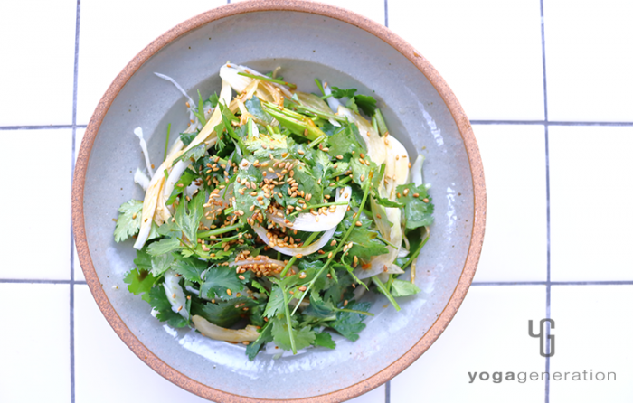 グレーの皿に盛り付けたセロリと新玉ねぎ、パクチーのピリ辛ゴマサラダ