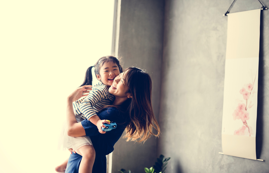 母親が少女を抱っこして微笑んでいるところ