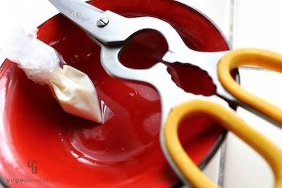 赤い皿に乗ったハサミと小さなビニール袋