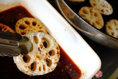 焼き色のついたレンコンを合わせ調味料に浸す