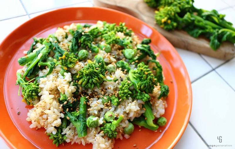 オレンジの皿に乗った菜の花の玄米サラダ