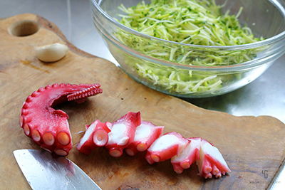 タコとズッキーニを刻む