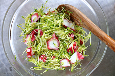 ボウルにタコとズッキーニを入れて調味料とあえる