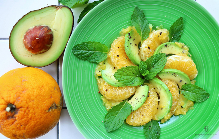 緑の皿に並べたアボカドと甘夏のサラダ