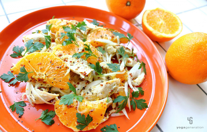 オレンジ色の皿に乗ったオレンジとチキンのサラダ