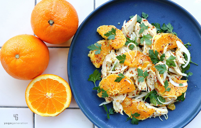 ネイビーの皿に乗ったオレンジとチキンのサラダ