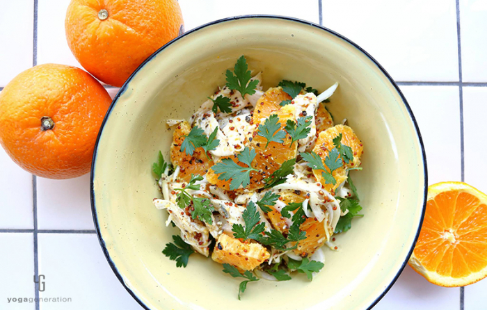 クリーム色の皿に乗ったオレンジとチキンのサラダ