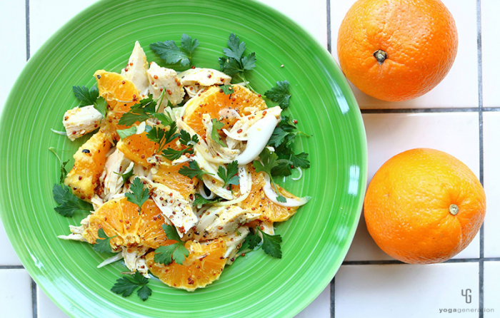 緑の皿に乗ったオレンジとチキンのサラダ