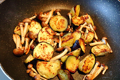 フライパンにナスとシメジを加える