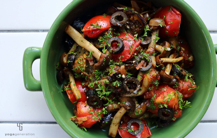 緑の器に入ったナスとトマトとベーコンのガーリック醤油炒め