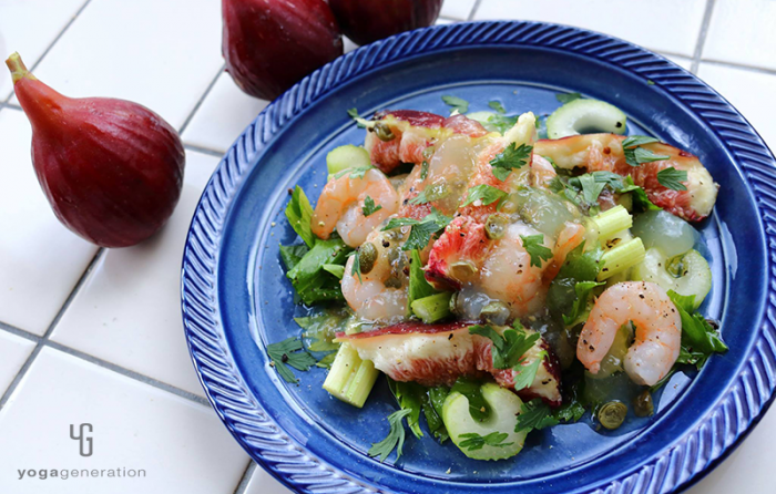 青い皿に乗ったイチジクとセロリ、エビのサラダ